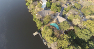 Ariel image of Chobe Bush Lodge in Africa. Green trees, deep/blu gray water.